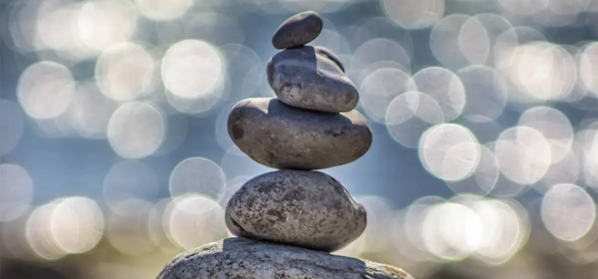 Pyramid of stones, stone sculpture, against the sky and water