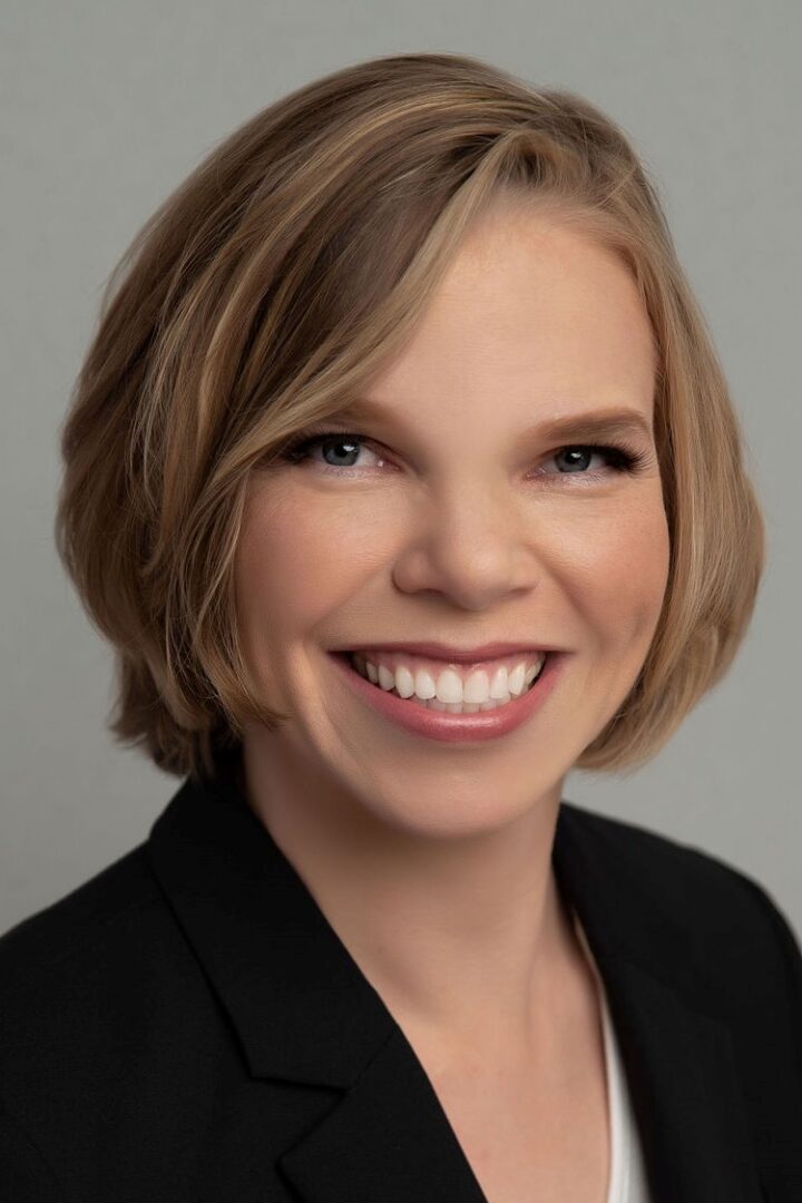 Smiling woman with short blonde hair.